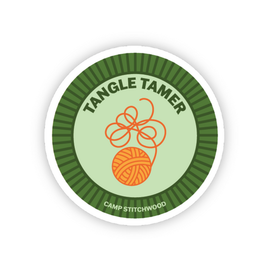 Circular sticker with 'Tangle Tamer' and 'Camp Stitchwood' text on a green and white background