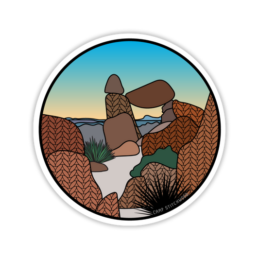 Round sticker with desert landscape design featuring rocks and a clear sky.