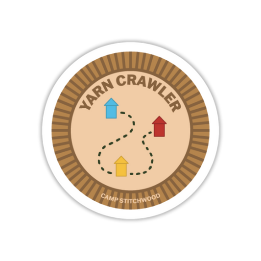 Circular sticker with 'Yarn Crawler' design and 'Camp Stitchwood' text on a white background