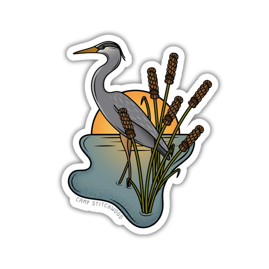 Sticker of a heron among reeds with a sunset background, featuring the brand 'Camp Stitchwood'.