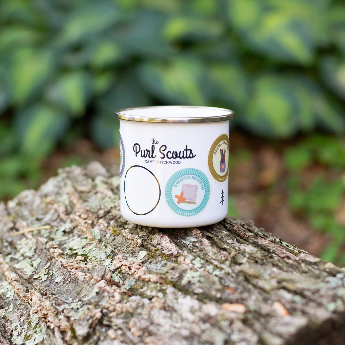 The Purl Scouts Camp Mug outside on a log