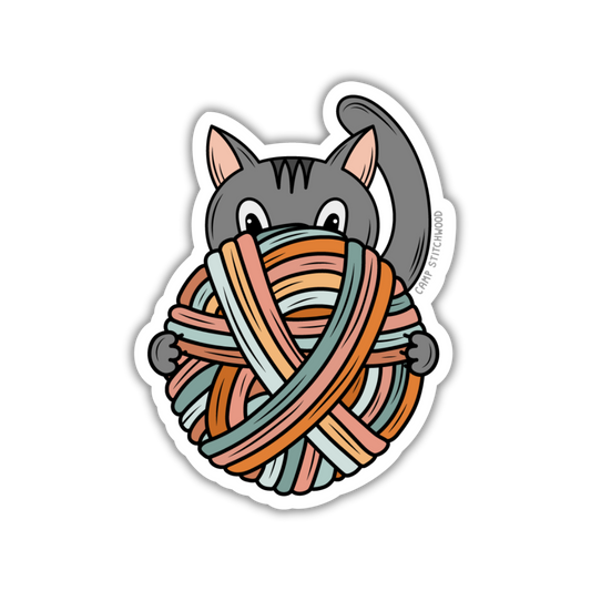 Sticker of a cat holding a colorful yarn on a white background