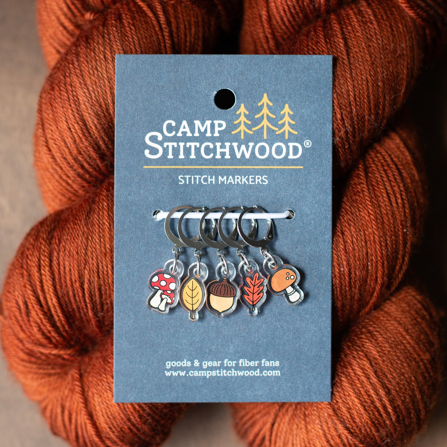Fall forest stitch markers with yarn in the background