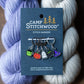 A set of Halloween stitch markers on purple and gray yarn