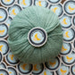Green skein of yarn with a 'Late Night Crafter' label on a patterned background