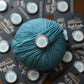Blue yarn ball with a snowbound stitcher merit badge