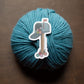 Blue yarn ball with a decorative mailbox sticker on a brown background
