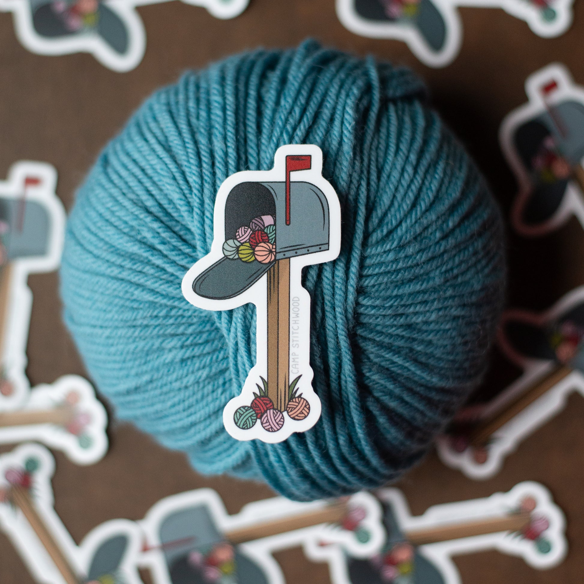 Blue yarn ball with a decorative sticker on a brown background