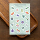 Sheet of 'Pollinators' stickers on a wooden surface