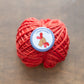 Craftivist badge on red yarn