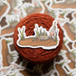 Yarn ball with a crab sticker on a patterned background