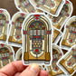 Hand holding a sticker of a vintage jukebox design with more stickers in the background.