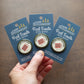 A hand holding three Loose End Loathing merit badges