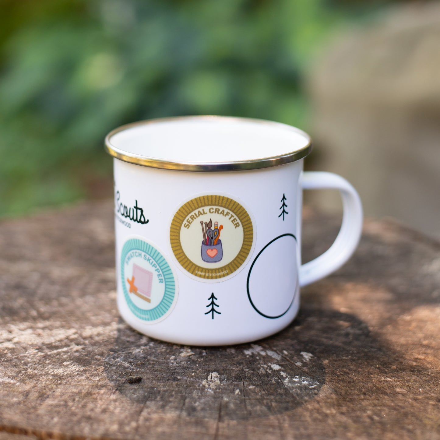 The Purl Scouts Camp Mug outside on a log, closeup
