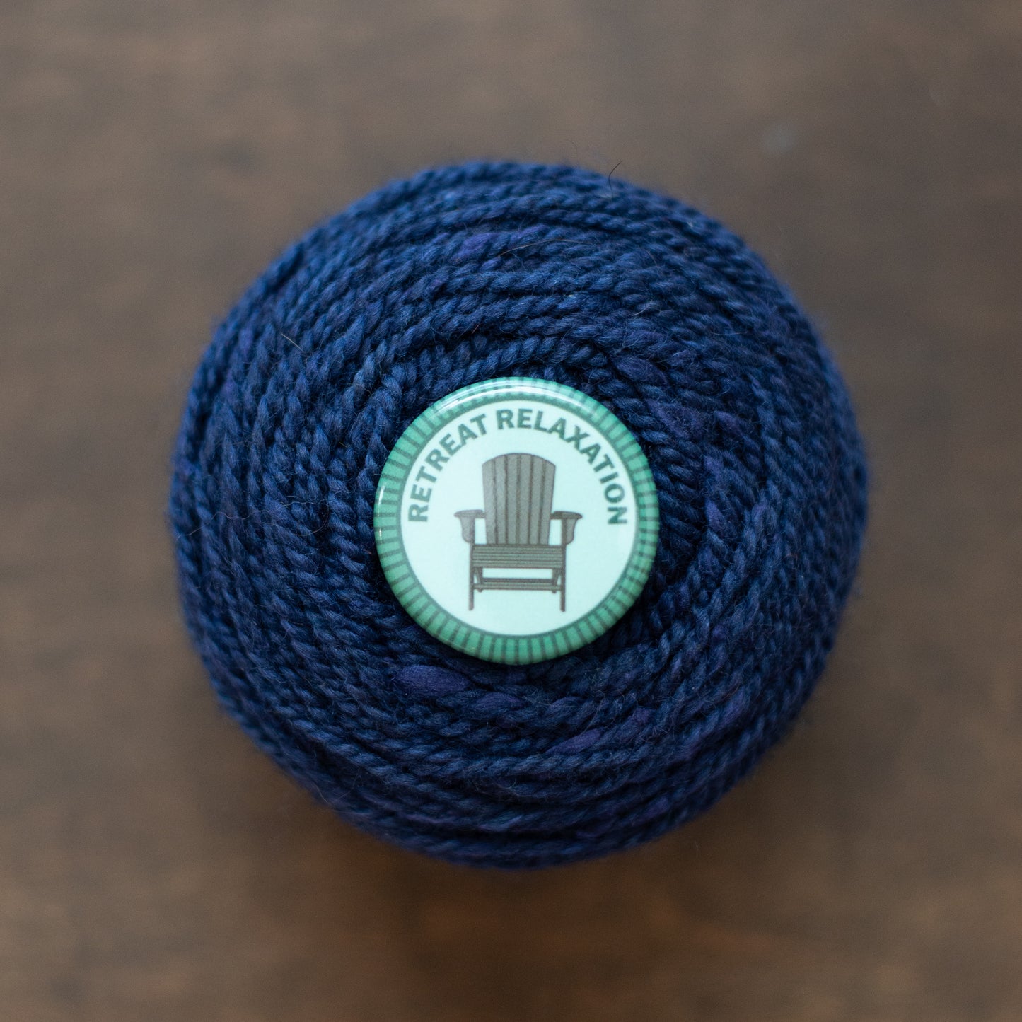 Retreat Relaxation badge on dark blue yarn