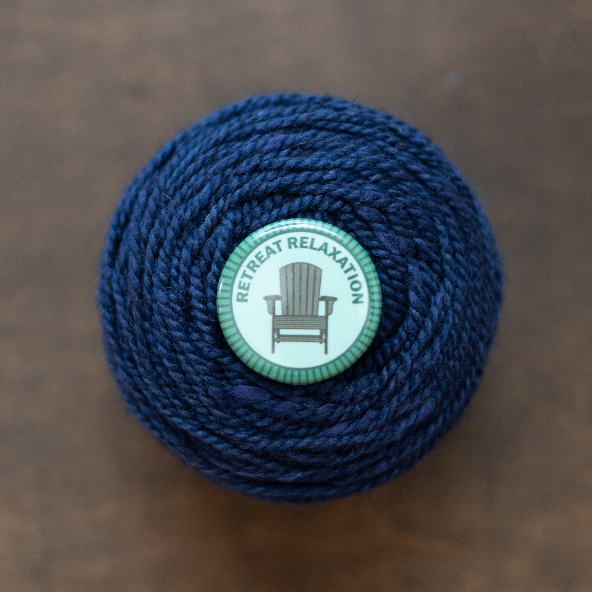 Retreat Relaxation badge on dark blue yarn