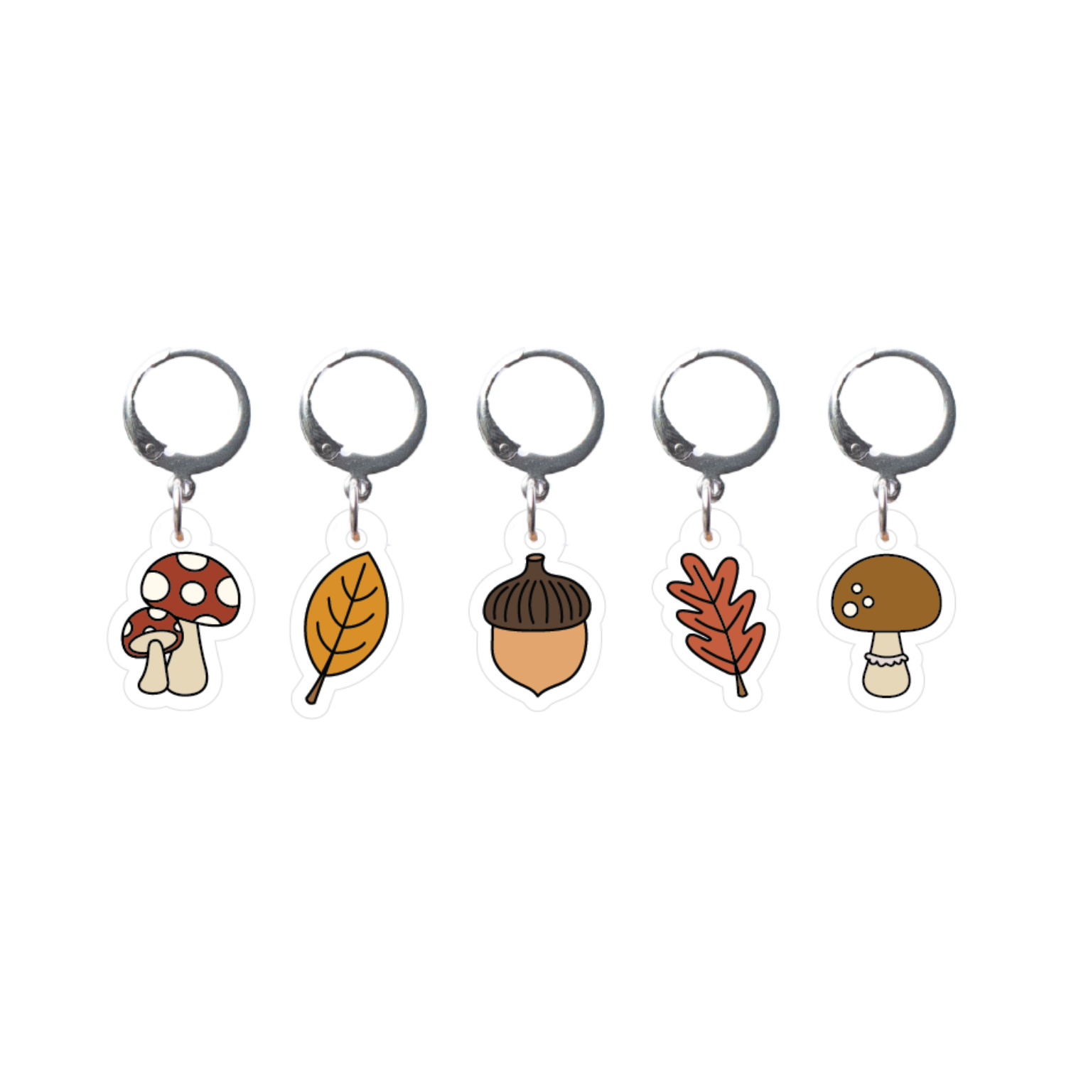 Set of five stitch markers with autumn-themed charms on a white background