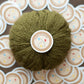 Yarn Crawler sticker on olive green yarn